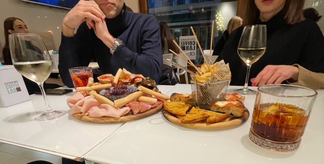 •	An assortment of Italian aperitivo food including cheese, cured meats, olives and cocktails at a cafe in Turin, Italy